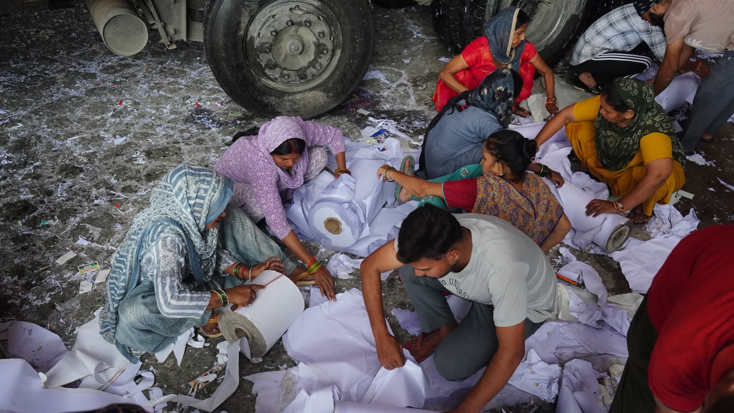 Mill crew wrapping and loading finished paper reels onto a truck for dispatch