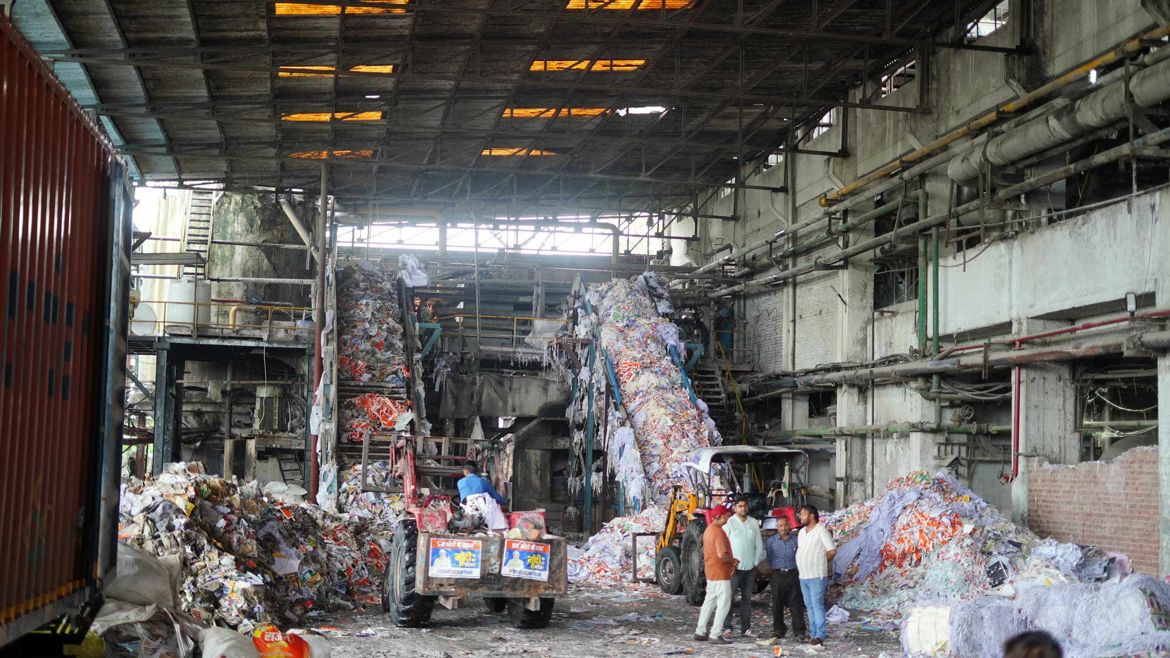 The recovery hall at Katyayini Mills in daylight, twin feed conveyors rising above the sorted stock