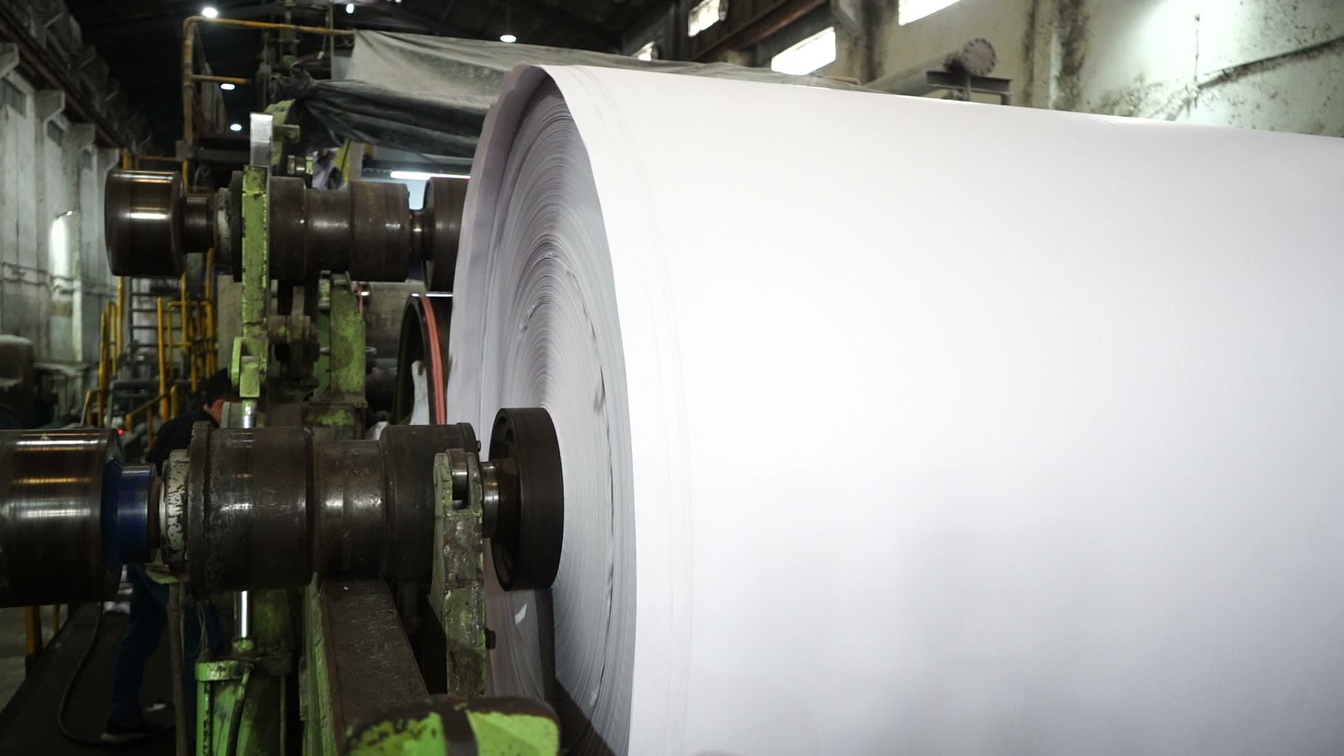 A jumbo reel of finished paper turning at the pope reel