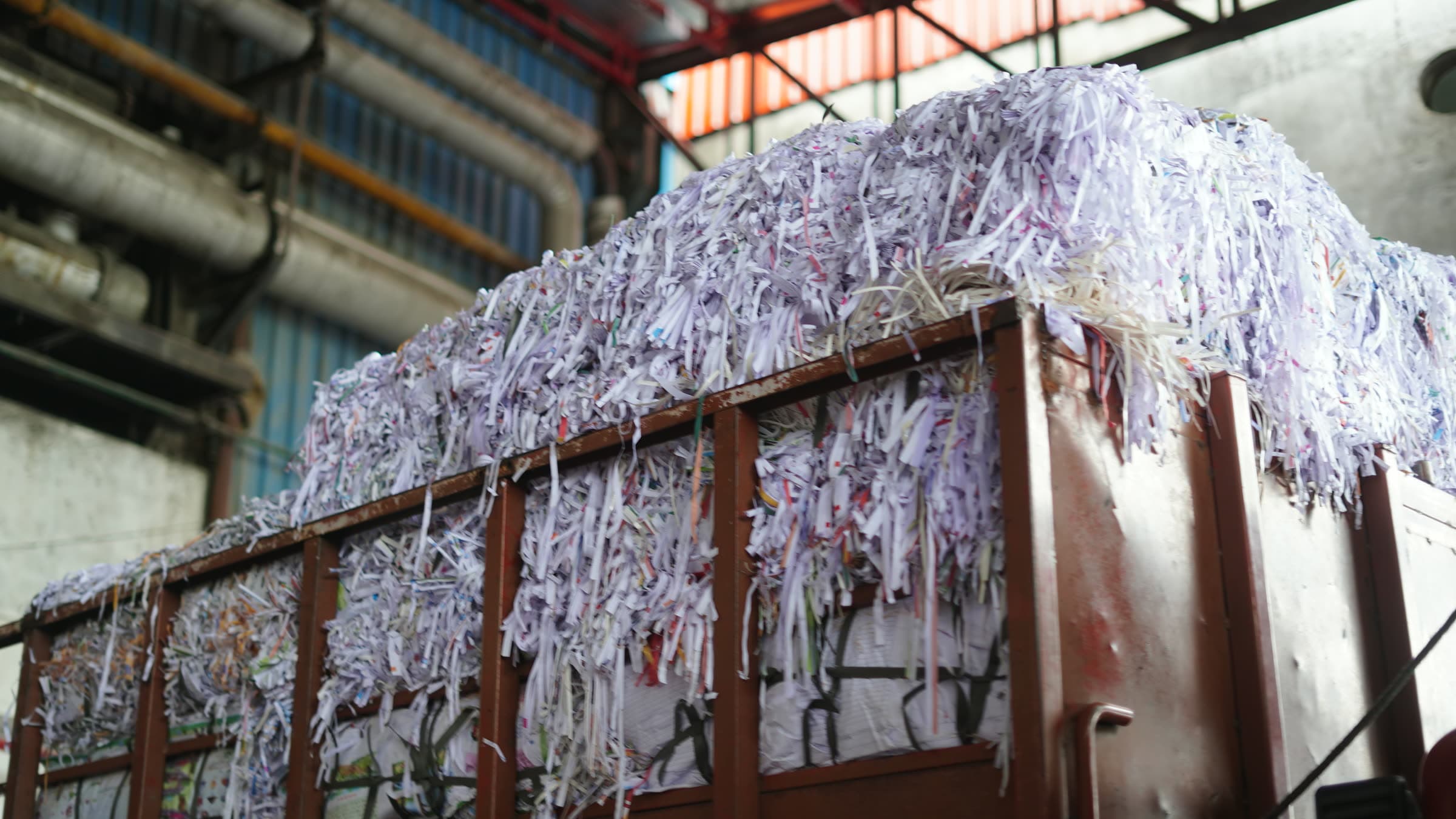 A trailer heaped with shredded paper stock inside the mill