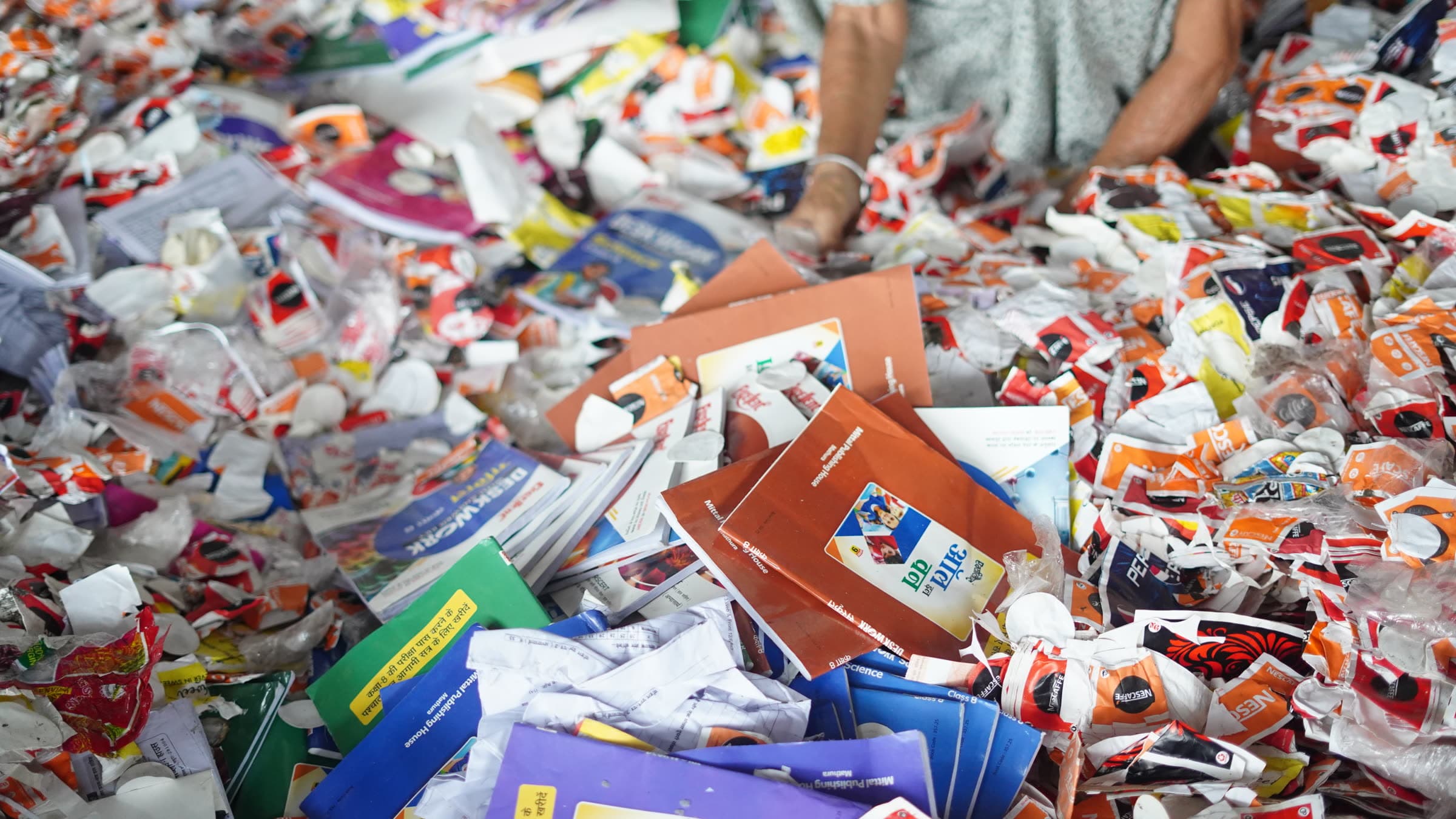 Close view of incoming recovered paper — used notebooks, cartons and printed wrappers