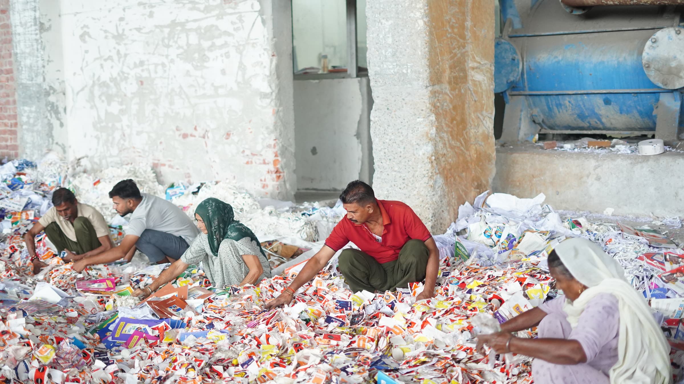 Mill crew segregating incoming waste paper by grade on the sorting floor